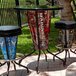 A Holland Bar Stool United States Marine Corps LED pub table with three bar stools on a patio.