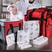 A chef using a Nordic foam brick cold pack to pack food in a white bag.