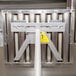 A metal frame with a yellow handle attached to it for lifting hood filters.