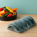 A yellow stone holder filled with yellow and orange bell peppers on a table.