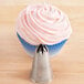 A cupcake with pink frosting on top with a silver Ateco 846 closed star piping tip nozzle.