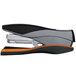 A close-up of a black and orange Swingline stapler.