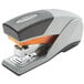 A grey stapler with an orange handle.