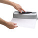 A person using a Swingline 3 hole punch to punch holes in paper.