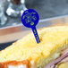 A sandwich with a blue plastic disc pick in the middle.