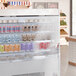 A 48-inch by 50-inch display cooler with a clear strip curtain, stocked with various beverages and food items.