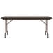 A Correll rectangular walnut folding table with legs and a black top.