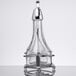 A clear glass Tablecraft oil and vinegar cruet with a metal base.