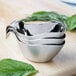 A stack of three stainless steel Tablecraft gravy boats.