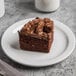 A piece of chocolate cake on a Libbey Porcelana narrow rim porcelain plate.