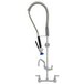 A Fisher stainless steel wall mounted pre-rinse faucet with an attached hose.