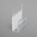A clear plastic Snap Drape table skirt clip with a white surface.