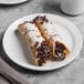 A Libbey Porcelain plate with two chocolate covered crepes and a cup of coffee on it.