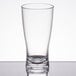 A clear GET SAN plastic shot glass on a reflective surface.