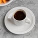 A Libbey Porcelana espresso cup of coffee on a saucer.
