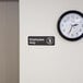 A black and white Vollrath Employees Only sign on a wall above a door.