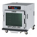 A Metro C5 9 Series undercounter heated holding and proofing cabinet with a clear glass door on wheels.