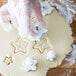 a person's hand in gloves making cookies
