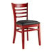 A red wooden Lancaster Table & Seating chair with black vinyl seat.