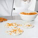 Sweet Toasted Coconut Flakes being poured into a bowl.