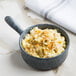 A bowl of macaroni and cheese in a Biseki blue stoneware oven skillet with a marbled handle.