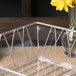 A clear plastic basket liner with a glass container of yellow flowers.