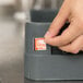 A hand using a Taylor TempRite manual dishwasher test label.