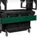 A green Cambro tray rail on a black table.