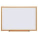 A Universal white melamine dry-erase board with an oak frame.