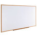 A Universal white melamine dry-erase board with an oak frame.