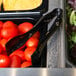 A tray of tomatoes with Sabert black plastic tongs.