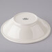 A Tuxton eggshell china pasta bowl on a gray surface.