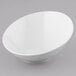 A Tuxton porcelain white serving bowl with a slanted design on a gray background.