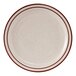 A close-up of a Tuxton white china plate with a brown speckled rim.