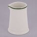 A white Tuxton china creamer with a green band.