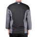 A man wearing a grey and black Chef Revival chef jacket with mesh on the back.