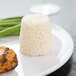 A plate of food with a Matfer Bourgeat rum baba on it served with rice and green beans.