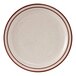 A white plate with a brown speckled surface and a red rim.