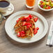 An Acopa narrow rim stoneware plate with French toast and strawberries on a table.