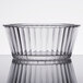 A clear fluted plastic ramekin with a rim.