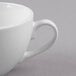 A close-up of a Libbey Basics bright white porcelain low cup with a handle.