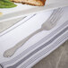 A Bon Chef Queen Anne stainless steel dinner fork on a plate with food