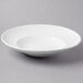 A Libbey Basics bright white porcelain entree/pasta bowl on a gray surface.