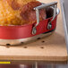 A Tablecraft natural high temp cutting board with a cooked turkey and ham in pans on a table.