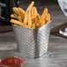 A Tablecraft stainless steel square fry cup with french fries and ketchup on a table.