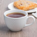 A Libbey Basics Orbis white porcelain cup of tea and pastry on a table.