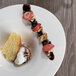 A white Libbey Orbis porcelain cup filled with dessert on a table.