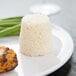 A white plate of food with a small round brown cake on it.