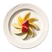 A Libbey Basics Orbis white porcelain plate with fruit slices and strawberries.