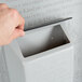 A hand opening a grey Koala Kare baby changing station.